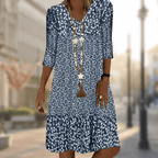 Blue floral V-neck dress with three-quarter sleeves and a gathered lower tier.