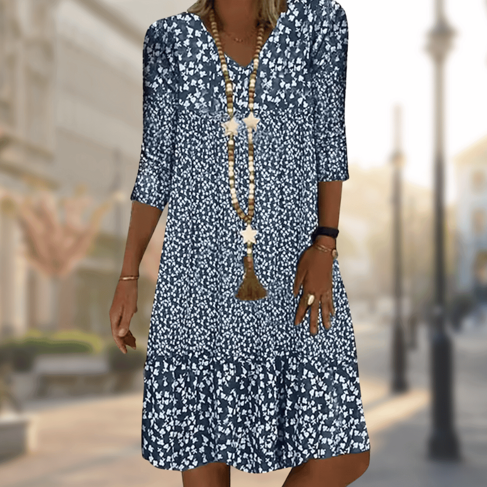 Blue floral V-neck dress with three-quarter sleeves and a gathered lower tier.
