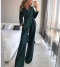 Dark green long-sleeve jumpsuit shown with one hand in a pocket.
