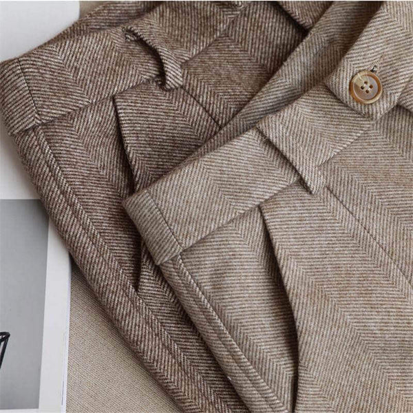 Close-up of herringbone-textured trousers with belt loops and pockets.
