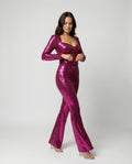Pink sequin jumpsuit with long sleeves and flared legs, shown from the front.