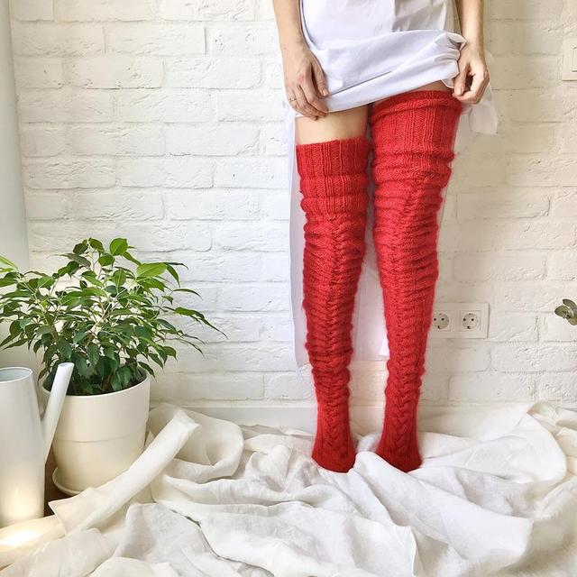 Red thigh-high socks with horizontal raised knit rows.