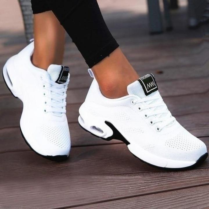 White lace-up trainers with dark tongue labels and sculpted heels.
