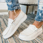 White lace-up shoes with rounded stitched toe panels.