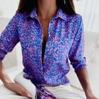 Purple and pink patterned blouse with a turn-down collar.