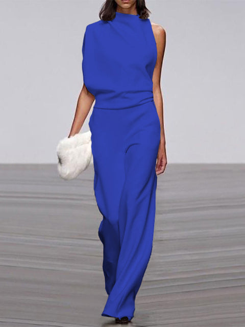 Blue jumpsuit with a high neckline and soft folds at the waist.