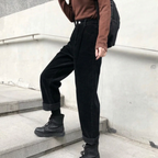 Black ribbed trousers worn with turned-up hems and boots.