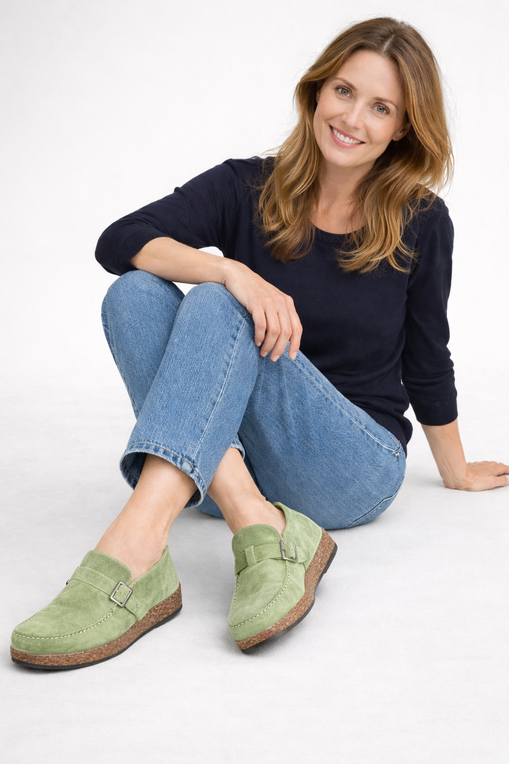 Light green open-heel clogs worn with jeans.