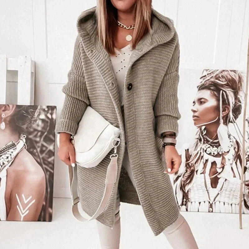 Beige-grey long cardigan worn open over pale trousers.