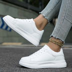 All-white trainers with stitched side panels and lace-up fronts.