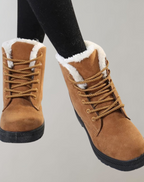 Brown lace-up ankle boots with white fluffy lining at the collar.