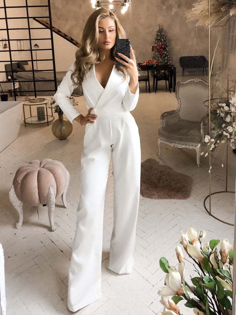White lapel jumpsuit with wide legs shown in a mirror.