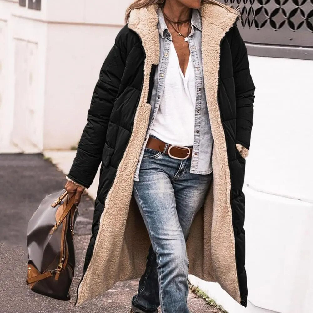 Black hooded long jacket with quilted panels and front pockets.