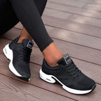 Black lace-up trainers with contrasting white sole sections.