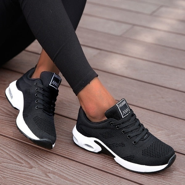 Black lace-up trainers with contrasting white sole sections.