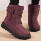Red winter boots worn with dark trousers, showing the upper straps and tall shafts.