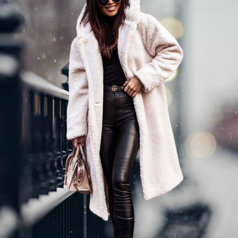 Creamy white long coat worn open over a black outfit.