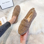 Khaki slippers shown on a foot and held up to display the upper and insole.