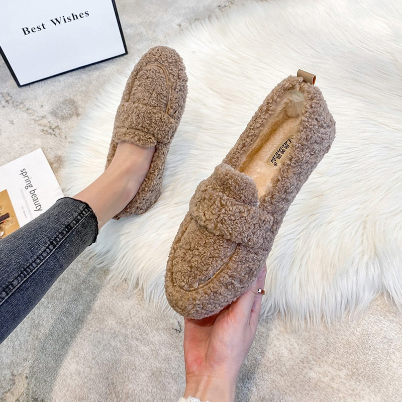 Khaki slippers shown on a foot and held up to display the upper and insole.