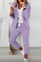 Purple open-front blazer and drawstring trousers shown with a contrasting top and white trainers.