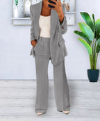 Grey two-piece suit with a lapel jacket and straight trouser legs.
