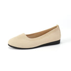 Beige flat shoe with a rounded toe.