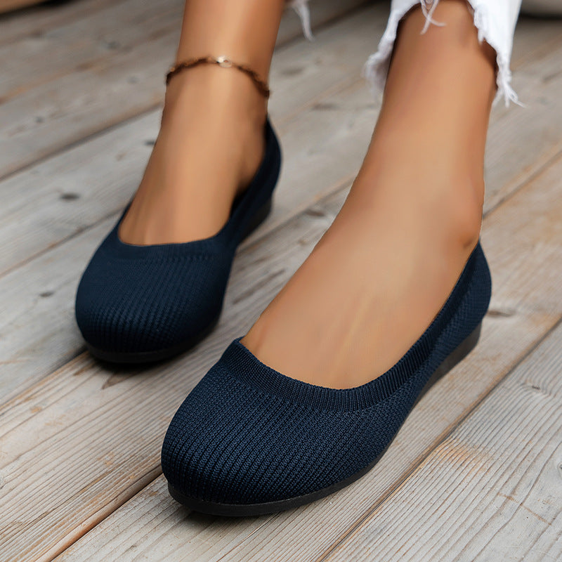 Navy blue flats with rounded toes and low openings.