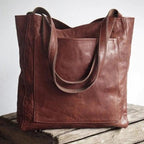 Dark coffee-brown shoulder tote with stitched edges and twin handles.