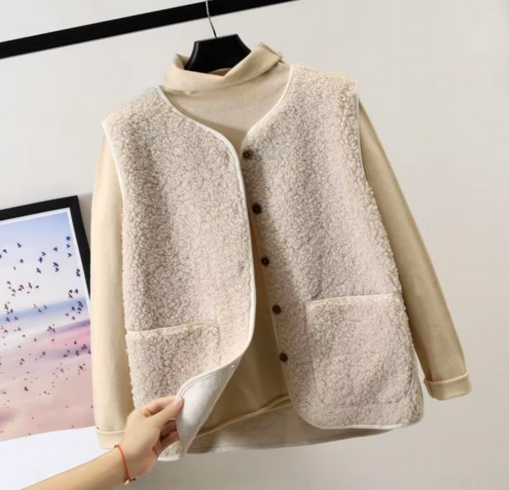 Light beige fleece gilet with dark buttons and bound edges.