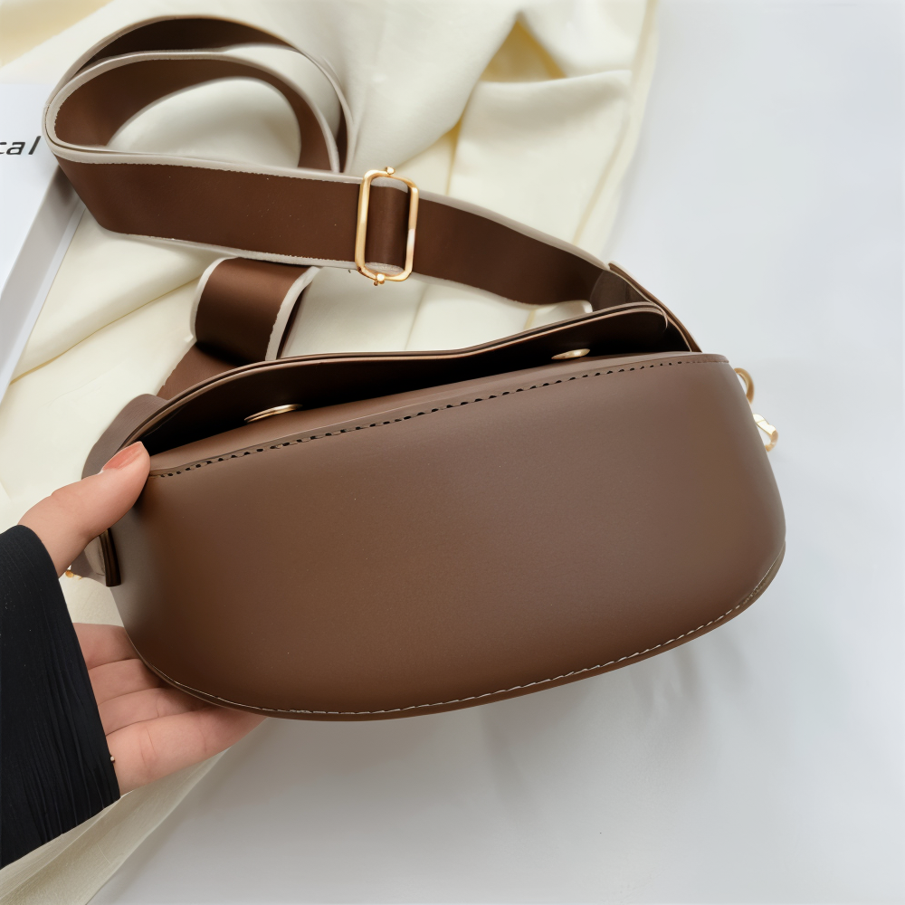 Close view of the brown bag interior and wide adjustable shoulder strap.
