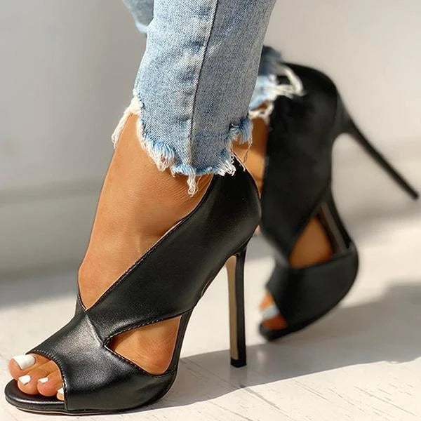 Black peep-toe heels worn with cropped jeans.