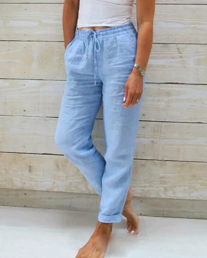 Blue cotton-linen trousers shown with a white top.