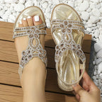 Gold-coloured sandals with flower-shaped trim and open toes.
