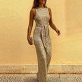 Gold sequin jumpsuit with a round neckline, sleeveless cut and fabric waist tie.