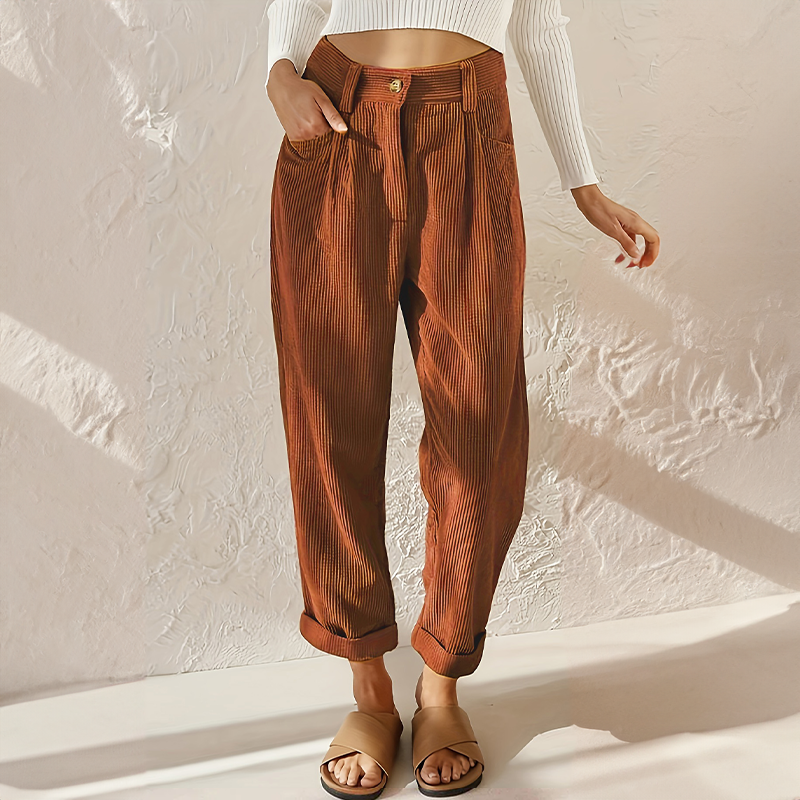 Rust-coloured corduroy trousers with a button at the waist.