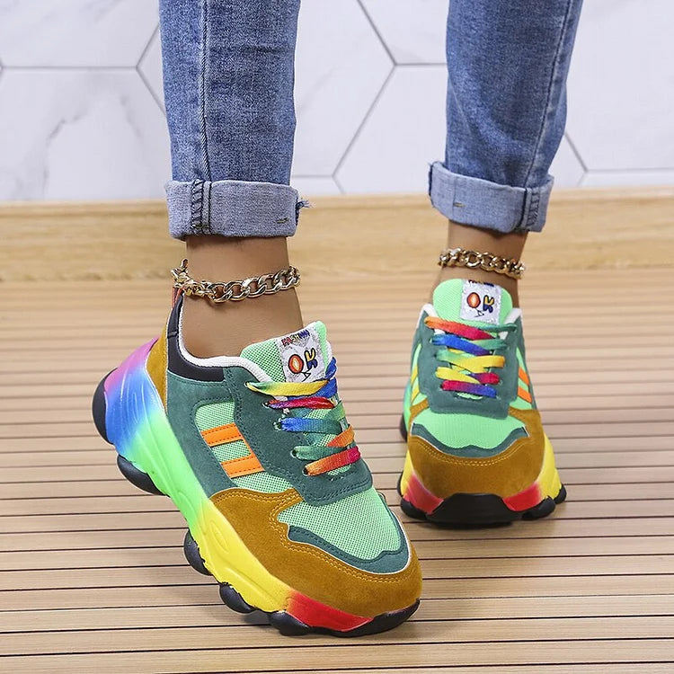 Green and mustard sneakers with multicoloured soles, worn with rolled jeans.