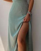 Close view of the high slit in a green long dress.