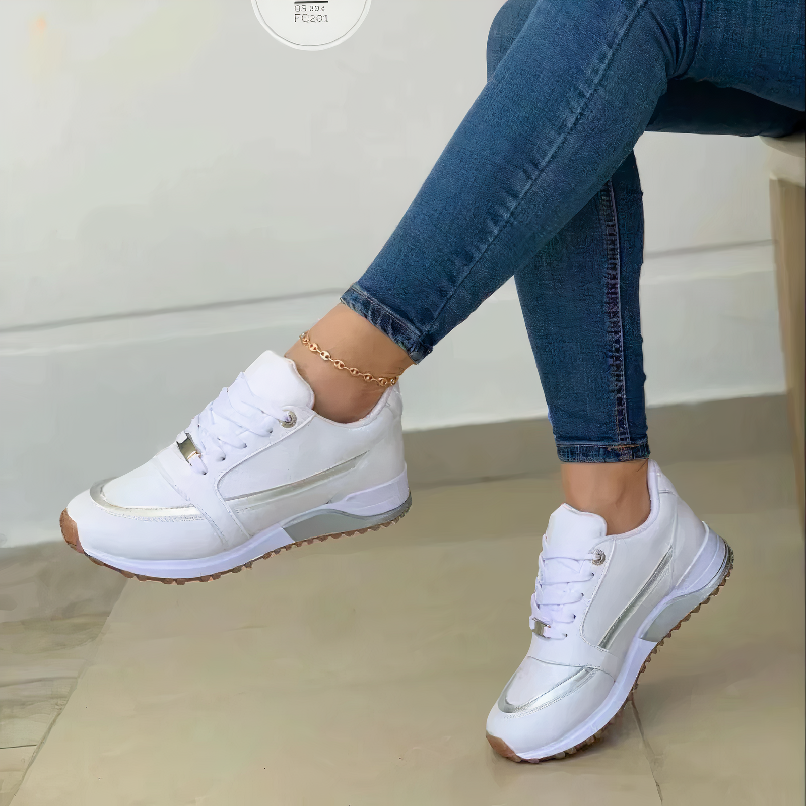 White trainers with pale silver-coloured trim and a raised sole.