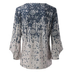 Back view of a pale blouse with a blue floral print and flared sleeves.