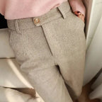 Light neutral pleated trousers worn with a pink top.