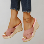 Pink wedge sandals shown from the front.