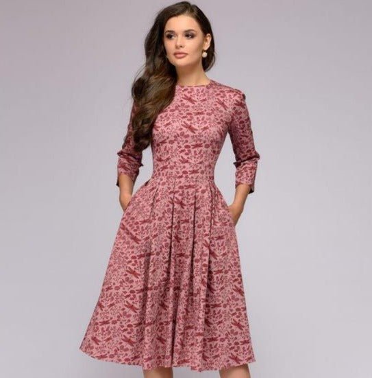 Pink patterned dress with a fitted waist and side pockets.