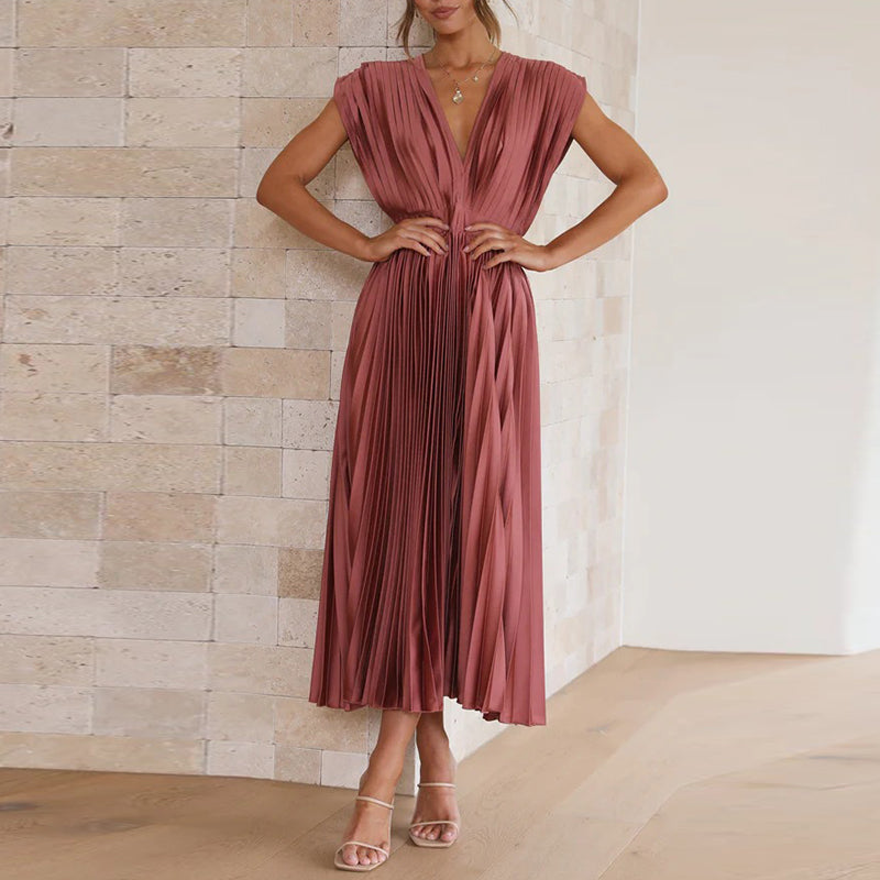 Rose-red pleated dress shown with hands at the waist.