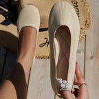 Beige flat held to show its light-coloured insole.