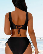 Rear view of the black lace-up bikini beside the sea.