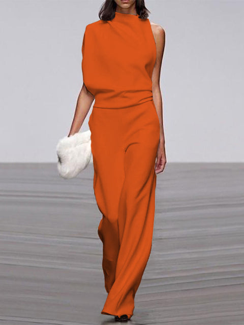 Orange sleeveless jumpsuit with long wide legs, worn with a white clutch.