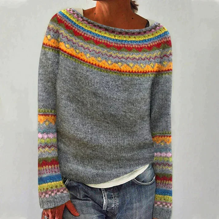 Grey jumper with bright patterned bands around the neckline and sleeves.