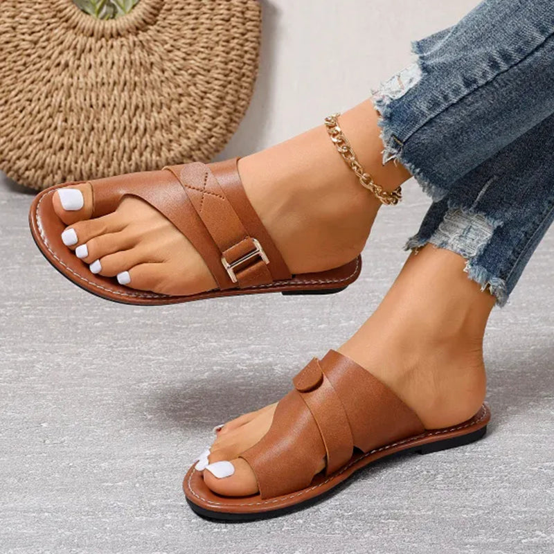 Brown open-heel sandals with crossing upper panels and stitched edges.
