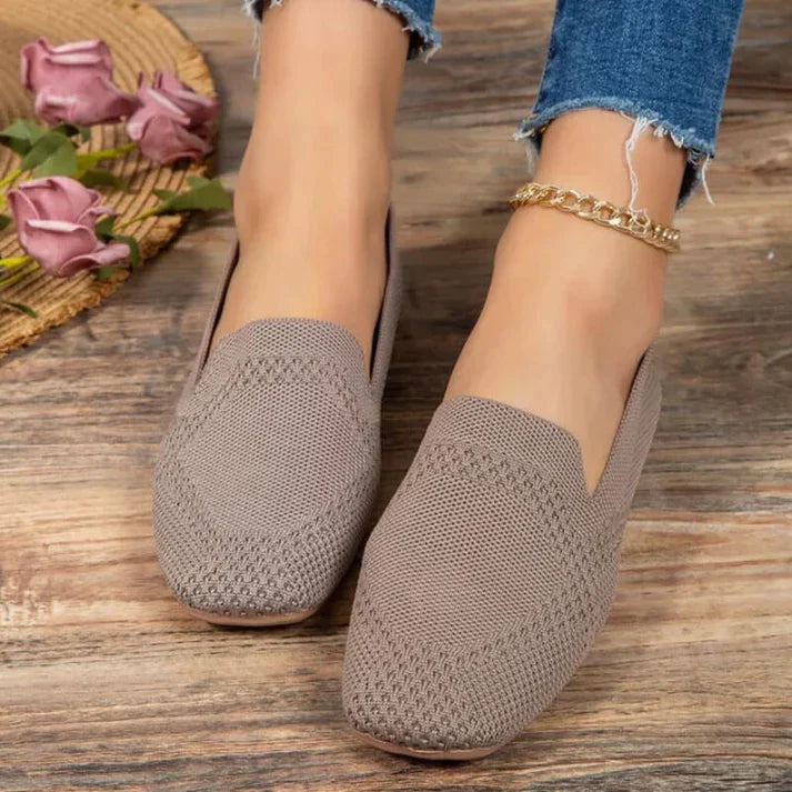 Grey slip-on flats with a patterned knit-like texture across the toes.