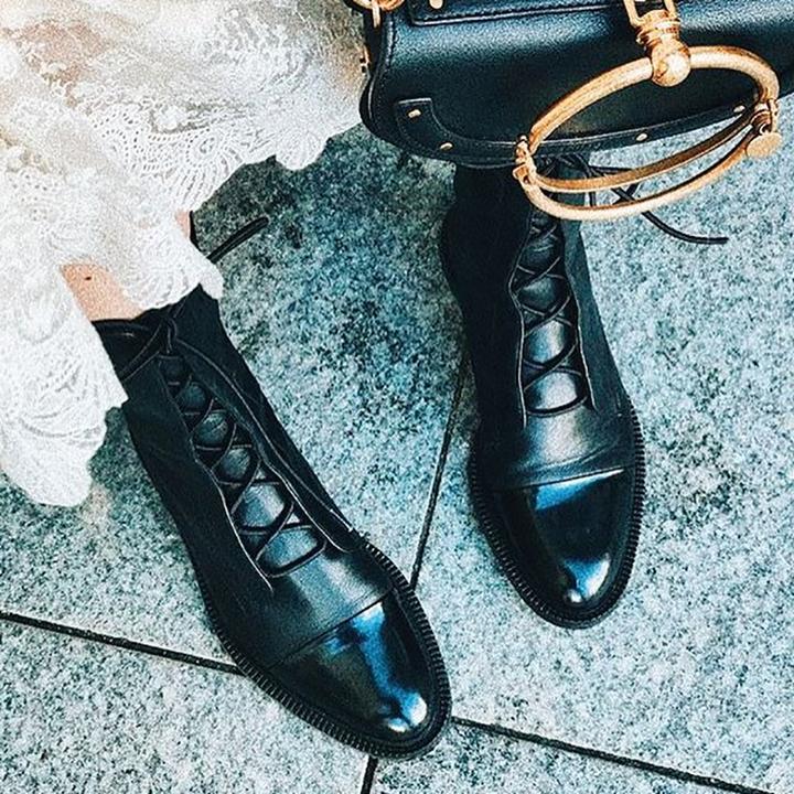 Black lace-up boots worn with white lace clothing.